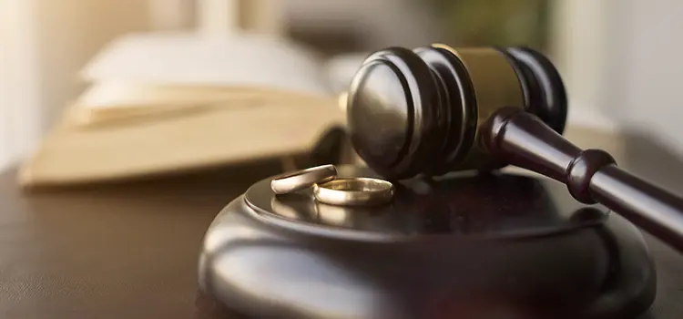 A judge's gavel with 2 wedding rings.